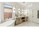 Bright bathroom featuring a soaking tub, double sinks, modern fixtures, and a glass-enclosed shower at 40614 N Harbour Town Ct, Anthem, AZ 85086