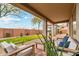 Inviting covered patio with flagstone flooring, neutral outdoor furniture, and a view of the landscaped backyard at 40614 N Harbour Town Ct, Anthem, AZ 85086