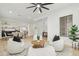 Cozy living room with stylish seating arrangement, neutral decor, and seamless transition to the dining area at 40614 N Harbour Town Ct, Anthem, AZ 85086