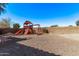 Backyard with a vibrant playset and a low-maintenance desert landscape at 41838 W Anne Ln, Maricopa, AZ 85138