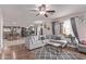 Open concept living room featuring hardwood floors, ceiling fan, and access to the kitchen at 41838 W Anne Ln, Maricopa, AZ 85138