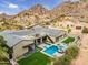 Stunning aerial view of a luxury home with a pool, spa, modern design, and mountain backdrop at 5301 E Paradise Canyon Rd, Paradise Valley, AZ 85253