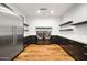 Large laundry room featuring stainless steel appliances, wooden floors, dark cabinetry and shelving at 5301 E Paradise Canyon Rd, Paradise Valley, AZ 85253