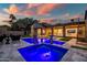 Luxury home with a pristine pool, featuring a spa and elegant outdoor seating under a colorful sunset at 5301 E Paradise Canyon Rd, Paradise Valley, AZ 85253