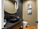 Stylish powder room featuring dark tiles, a vessel sink, and elegant fixtures at 5301 E Paradise Canyon Rd, Paradise Valley, AZ 85253