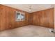 Bedroom with wood paneled walls, plush carpet and a window providing natural light at 5401 S Siesta Ln, Tempe, AZ 85283