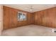 Bedroom with wood paneled walls, plush carpet and a window providing natural light at 5401 S Siesta Ln, Tempe, AZ 85283