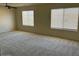 Spacious bedroom with large windows, plush carpeting and overhead ceiling fan with light at 6780 W Yearling Rd, Peoria, AZ 85383