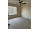 Bright bedroom featuring a ceiling fan, carpeted floors, and a window bringing in natural light at 6780 W Yearling Rd, Peoria, AZ 85383