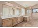 Bathroom featuring a double vanity with warm cabinets, neutral countertop and flooring, and tub-shower combo at 73 E Caroline Ln, Tempe, AZ 85284