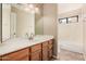 Bathroom featuring a large mirror, vanity with wood cabinets, and a combined tub and shower at 73 E Caroline Ln, Tempe, AZ 85284