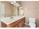 Bathroom featuring a neutral vanity and toilet, accented by a vanity mirror at 73 E Caroline Ln, Tempe, AZ 85284