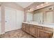 Bathroom featuring a double vanity with warm-toned cabinets, a neutral countertop and flooring at 73 E Caroline Ln, Tempe, AZ 85284