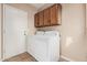 Laundry room with tile flooring, upper cabinets, and a washer and dryer for added convenience at 73 E Caroline Ln, Tempe, AZ 85284