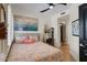 Bright bedroom featuring a ceiling fan, unique artwork, and ensuite bath with walk in closet at 7420 E Northland Dr # B101, Scottsdale, AZ 85251