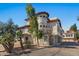 Stucco two-story home featuring a red tile roof, a charming turret, and mature landscaping at 7420 E Northland Dr # B101, Scottsdale, AZ 85251