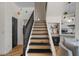 View of staircase featuring wooden treads and black risers with an adjacent living area at 7420 E Northland Dr # B101, Scottsdale, AZ 85251