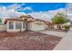 Attractive single-story home showing tile roof, desert rock landscaping, and two-car garage at 7929 W Wescott Dr, Glendale, AZ 85308