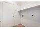 White laundry room including tile flooring, shelving and a door to the outside at 7929 W Wescott Dr, Glendale, AZ 85308