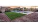 Backyard showcasing a pool with waterfall feature, lush turf, and outdoor seating at 9547 W Chama Dr, Peoria, AZ 85383