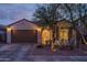 Dusk view of a cozy home featuring a two-car garage and drought-resistant landscaping at 9547 W Chama Dr, Peoria, AZ 85383