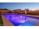 Backyard pool featuring underwater lighting and a gentle waterfall, creating a serene atmosphere for relaxation and evening entertainment at 9547 W Chama Dr, Peoria, AZ 85383