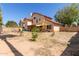 Expansive backyard with desert landscaping, featuring a covered patio ideal for entertaining, and a glimpse of neighborhood homes at 956 N 58Th St, Mesa, AZ 85205