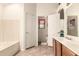 Bathroom with bathtub and vanity; open door leads to water closet with window at 956 N 58Th St, Mesa, AZ 85205