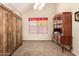 Bright bedroom with a wooden cabinet, neutral carpet, and a window with floral curtains at 956 N 58Th St, Mesa, AZ 85205