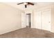 This bedroom offers neutral walls, carpet, ceiling fan, closet, and bathroom access at 956 N 58Th St, Mesa, AZ 85205