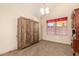 Cozy bedroom with a rustic wardrobe, neutral carpet, and a bright window with floral curtains at 956 N 58Th St, Mesa, AZ 85205