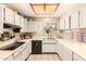 Well-lit kitchen featuring white cabinets, light countertops, tiled flooring, and modern appliances at 956 N 58Th St, Mesa, AZ 85205