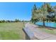 Scenic view of the golf course with a lush green landscape, picturesque lake, and blue sky at 10317 W Desert Forest Cir, Sun City, AZ 85351
