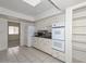 White kitchen featuring tile flooring, white cabinets, and modern appliances at 10317 W Desert Forest Cir, Sun City, AZ 85351