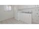 Laundry room featuring tile flooring, ample counter space, and a washer and dryer at 10317 W Desert Forest Cir, Sun City, AZ 85351