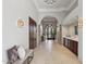 Inviting foyer featuring travertine floors, a wet bar, stone columns, and an arched doorway at 10801 E Happy Valley Rd # 86, Scottsdale, AZ 85255