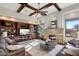 Spacious living room featuring a stone fireplace, custom built-ins, and beamed ceilings at 10801 E Happy Valley Rd # 86, Scottsdale, AZ 85255