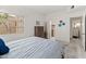 Bright bedroom features a wooden bed frame, tile floors, and a view of the hallway and bath at 11333 N 92Nd St # 1021, Scottsdale, AZ 85260