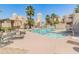 Community pool surrounded by lounge chairs, palm trees, and light-colored stucco buildings on a sunny day at 11333 N 92Nd St # 1021, Scottsdale, AZ 85260
