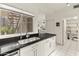 Galley kitchen with stainless steel sink, granite countertops, and white cabinets at 11333 N 92Nd St # 1021, Scottsdale, AZ 85260