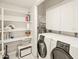 A bright laundry room with white washer and dryer, upper cabinets, and storage shelves for household supplies at 11333 N 92Nd St # 1021, Scottsdale, AZ 85260