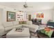 Open-concept living room with white tile floors, a white sectional sofa, and a modern ceiling fan at 11333 N 92Nd St # 1021, Scottsdale, AZ 85260