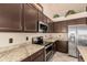 Close-up of the kitchen featuring granite countertops, stainless steel appliances, and dark wood cabinets at 1584 W Lark Dr, Chandler, AZ 85286