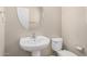 Bathroom features a pedestal sink, oval mirror, and white toilet with tile flooring at 17358 N 185Th Ln, Surprise, AZ 85374