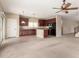 An open concept kitchen features dark wood cabinetry, black appliances, and a view into the living area at 17358 N 185Th Ln, Surprise, AZ 85374