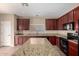 Modern kitchen with dark wood cabinets, granite countertops, and stainless steel appliances at 17358 N 185Th Ln, Surprise, AZ 85374