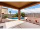 Inviting backyard with a covered patio and a sparkling pool with a rock waterfall feature and tropical landscaping at 17358 N 185Th Ln, Surprise, AZ 85374