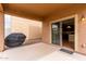 A covered patio with a view into the kitchen, featuring tile flooring and a sliding glass door at 17358 N 185Th Ln, Surprise, AZ 85374