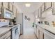 Efficient kitchen featuring white appliances and cabinetry, adjacent to a cozy dining nook and a bright window at 17443 N 99Th N Dr, Sun City, AZ 85373