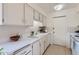 Well-maintained kitchen with white cabinetry and appliances, offering a clean and functional cooking space at 17443 N 99Th N Dr, Sun City, AZ 85373